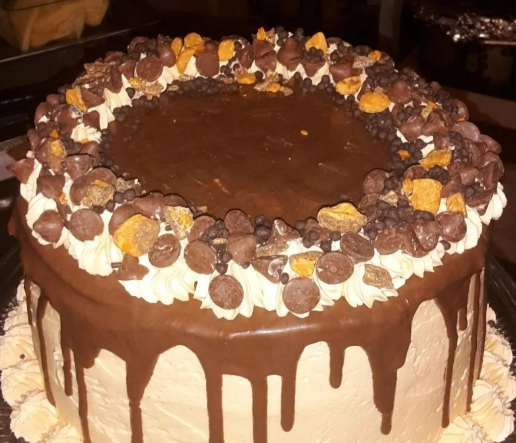 A chocolate drip cake piled with candy pieces
