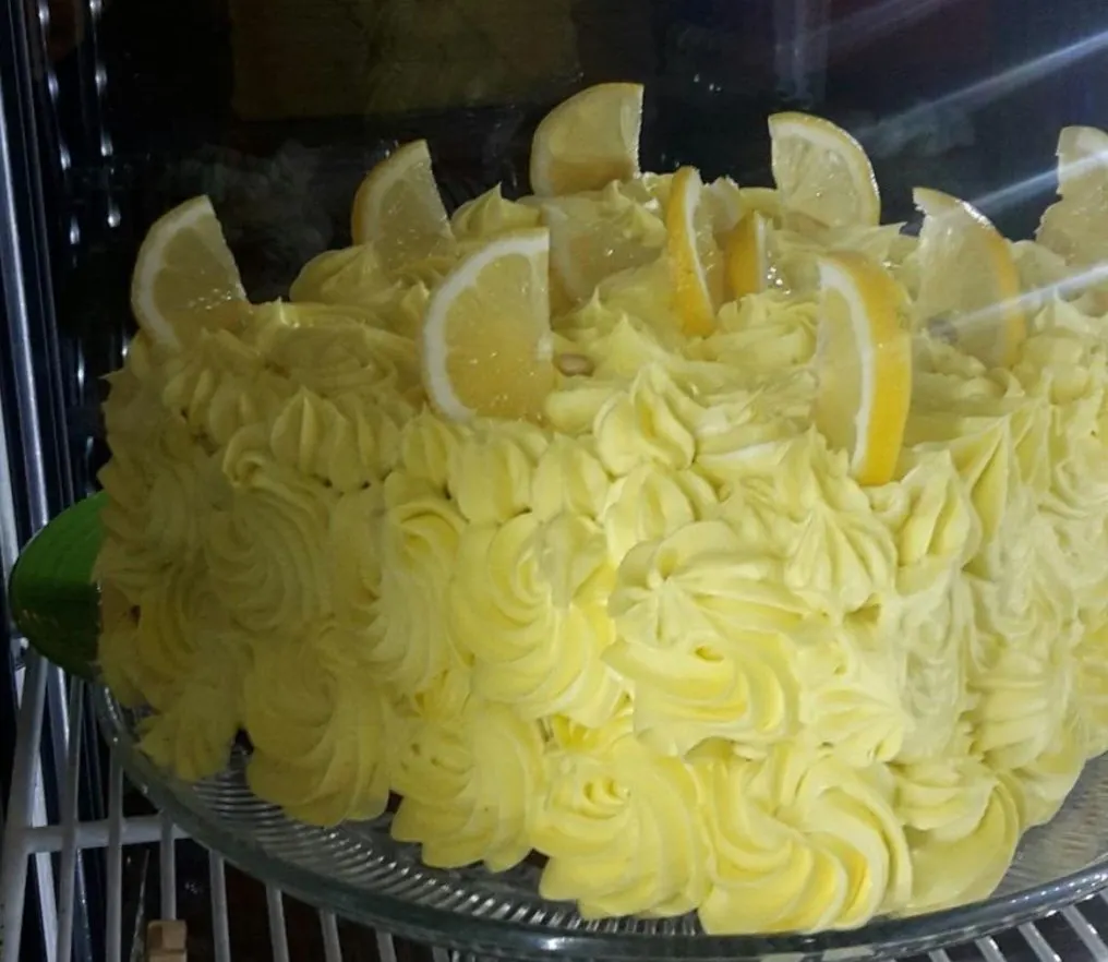 A yellow buttercream lemon cake topped with lemon slices