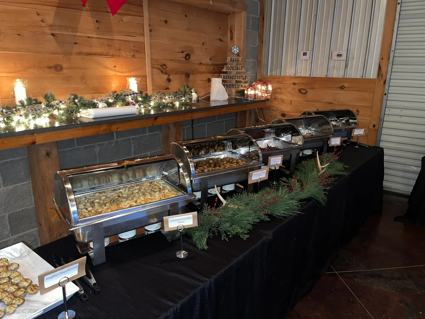 Chafing dishes and evergreen garland running the length of a buffet counter