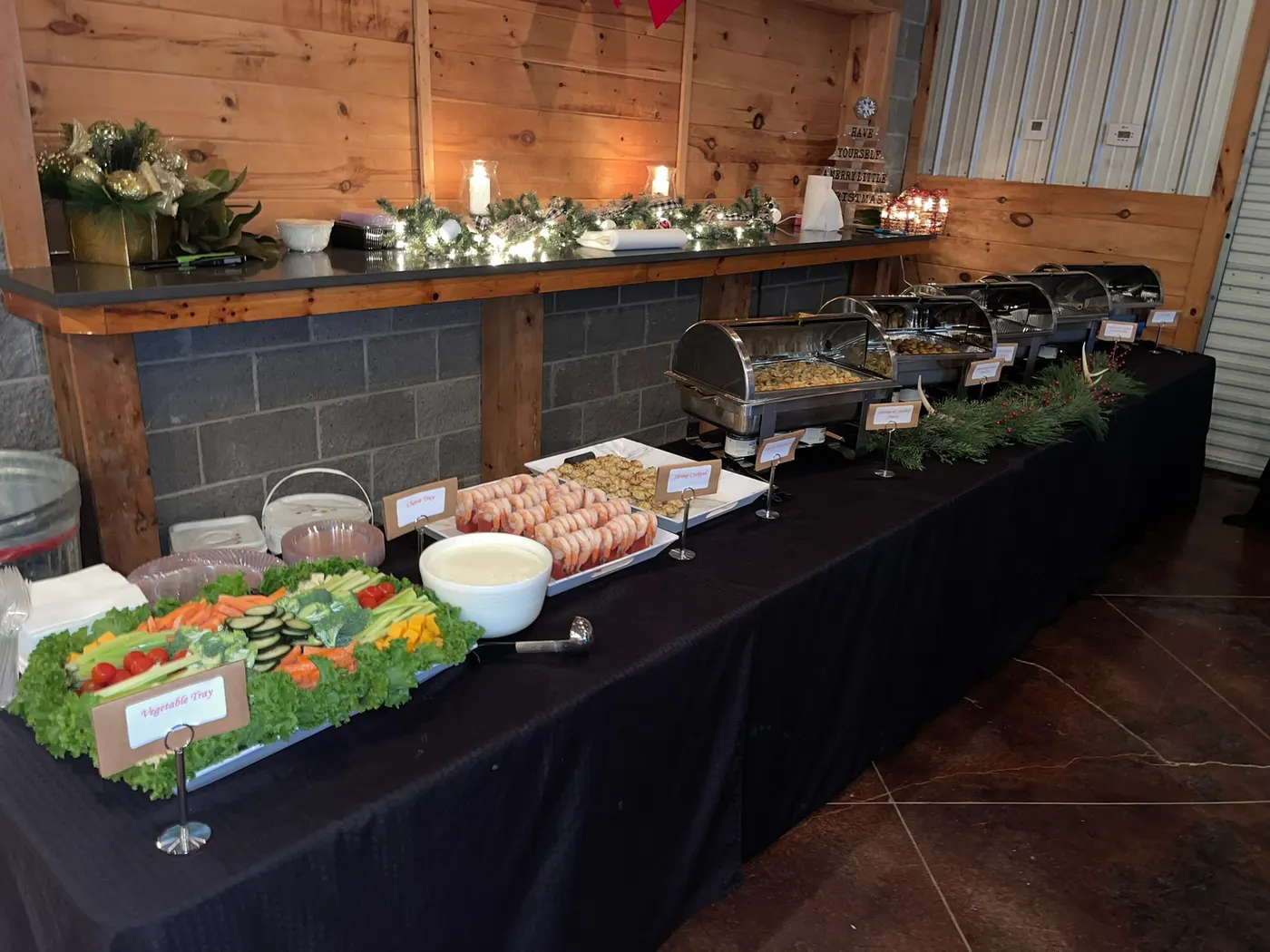 A salad and cold spread laid down a long buffet, with garland along the counter